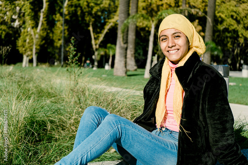 Beautiful young Latin cancer survivor, with a scarf covering her head
