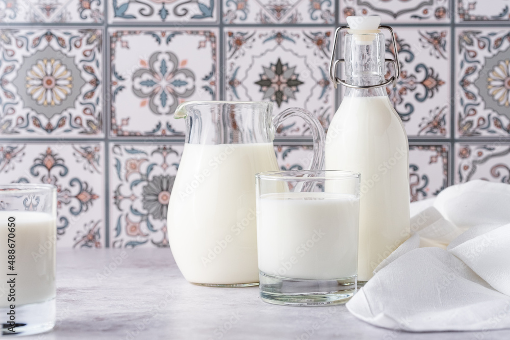 Milk in a glass, decanter and bottle on a light background Milk in a glass, decanter and bottle on a light background