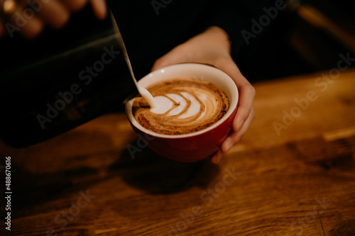 Pouring Latte Art in Red Mug photo