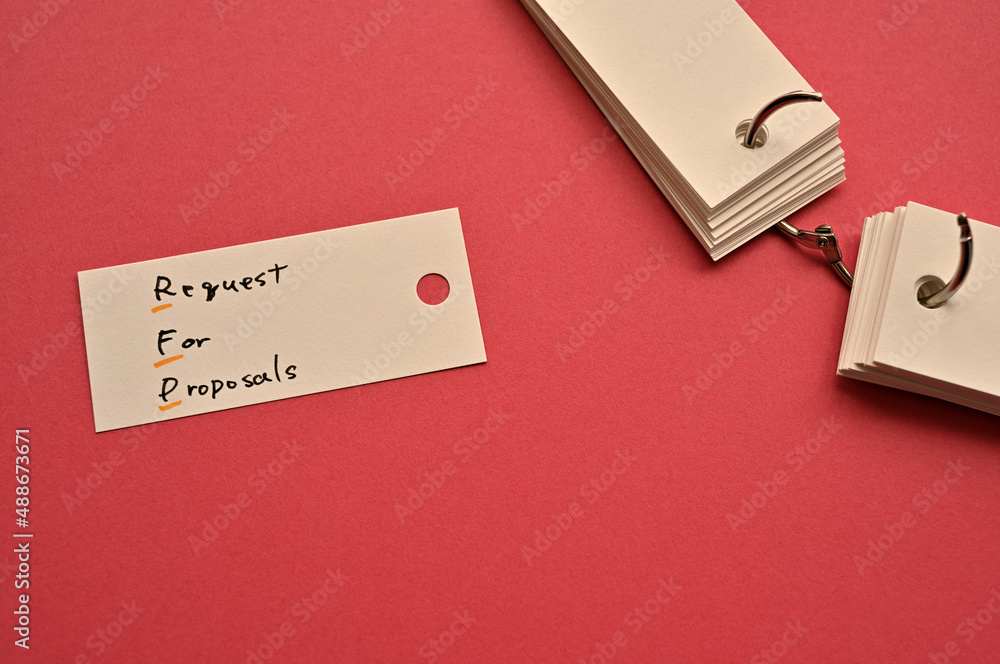 Fototapeta premium There is a small card placed on a red background paper with the word Request for Proposal written on it. Copy space available.