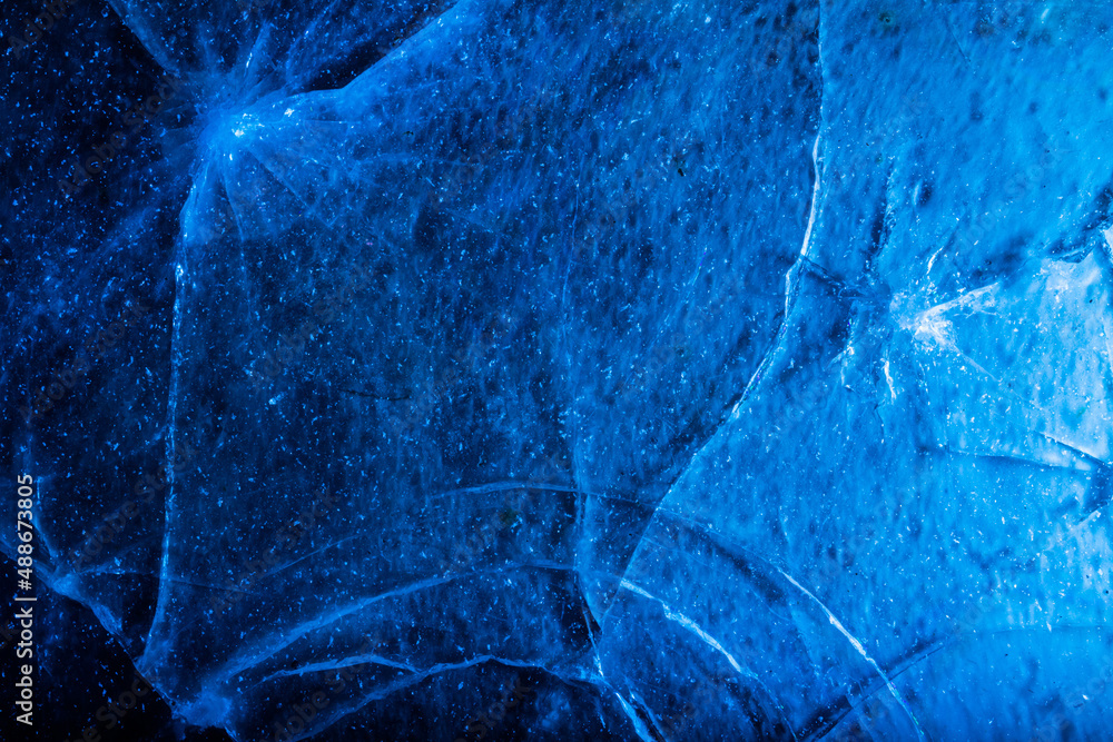 Photo of blue toned frozen crack line and damaged ice surface texture. Photo of blue toned frozen crack line and damaged ice surface texture.