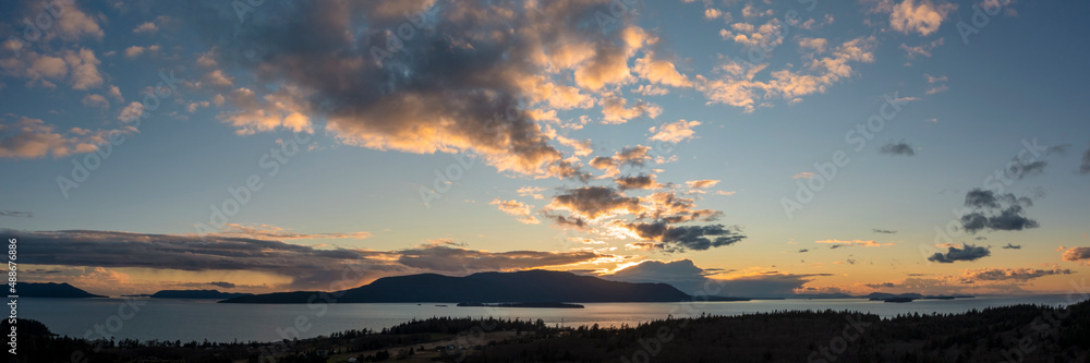 Fototapeta premium Sunset Over Orcas Island, Washington. Located in the San Juan Islands this drone view and dramatic clouds was taken from Lummi Island looking across Rosario Strait in the Salish Sea.