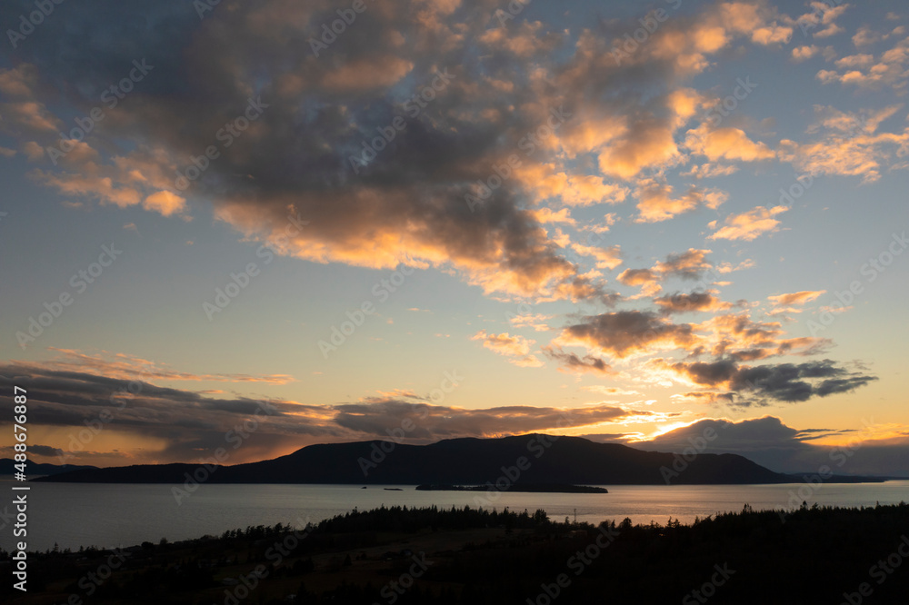 Sunset Over Orcas Island, Washington. Located in the San Juan Islands this drone view and dramatic clouds was taken from Lummi Island looking across Rosario Strait in the Salish Sea.