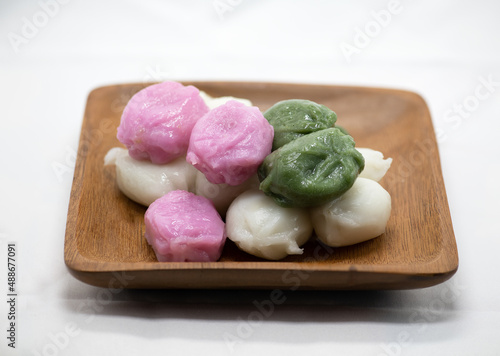 Korean food five colors honey rice cake served on a wooden plate on a white background