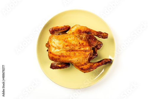 Roasted chicken on a plate isolated on white background. Top view