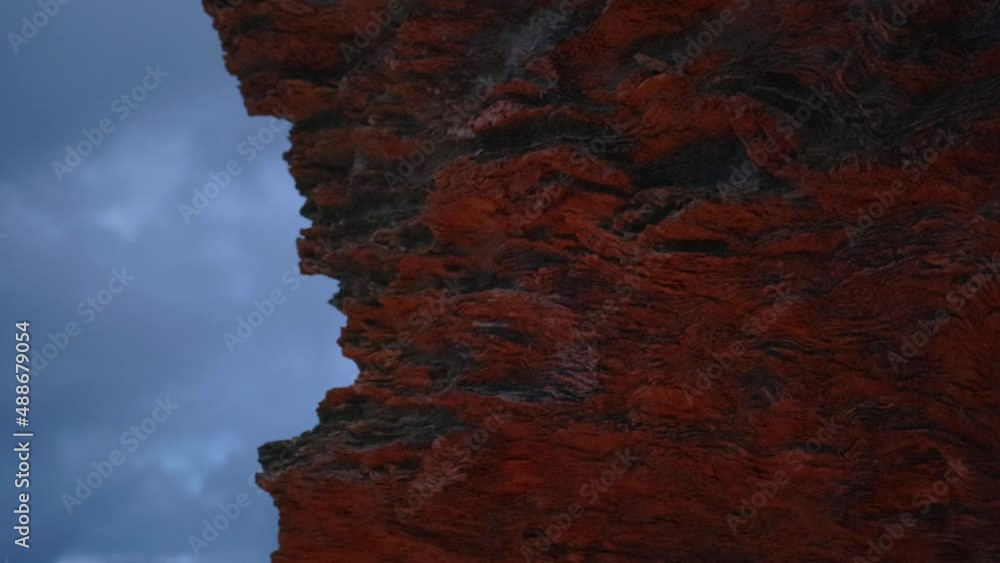 Rock shelf glowing in fire light against dusk sky Rock shelf glowing in fire light against dusk sky