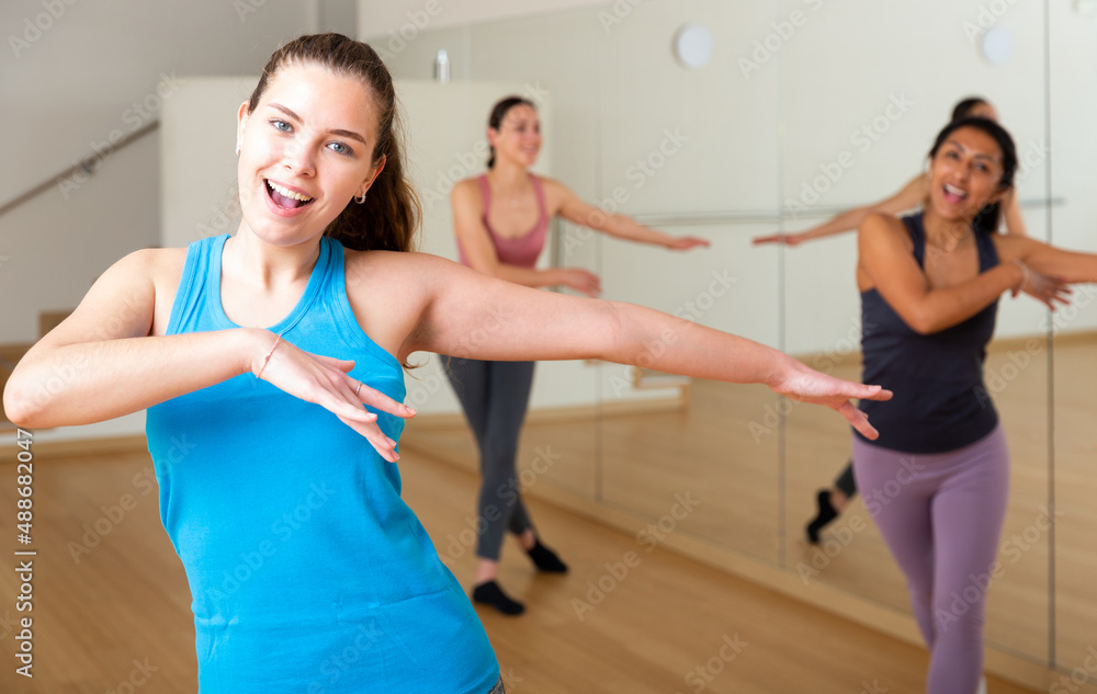 Positive slim athletic women dancing aerobics at lesson in the dance class