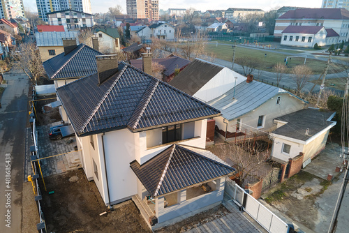 Aerial view of private house with ceramic shingles covered roof top. Investment in real estate concept © bilanol