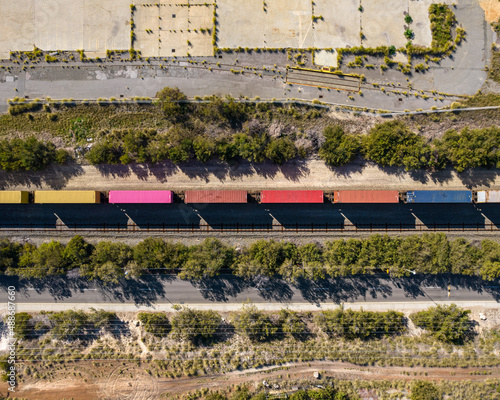 A cargo train carrying shipping containers passes through South Fremantle Industrial area