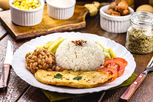 typical brazilian lunch rice and beans, grilled chicken fillet and fries, homemade food, rustic setting