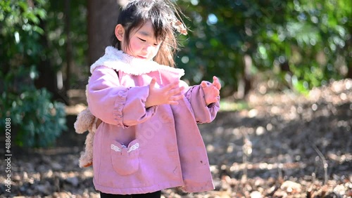 Girl playing with a large amount of fallen leaves