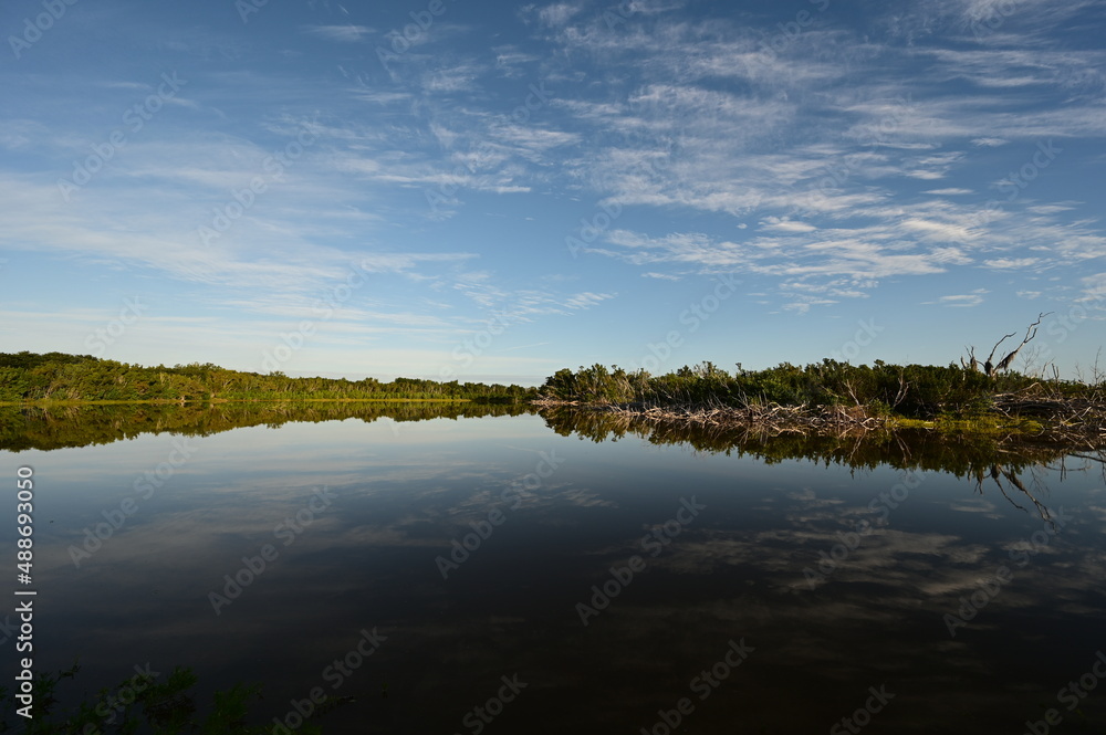 Morning clouds over Eco Pond in Everglades National Park, Florida reflected in pond's tranquil water.