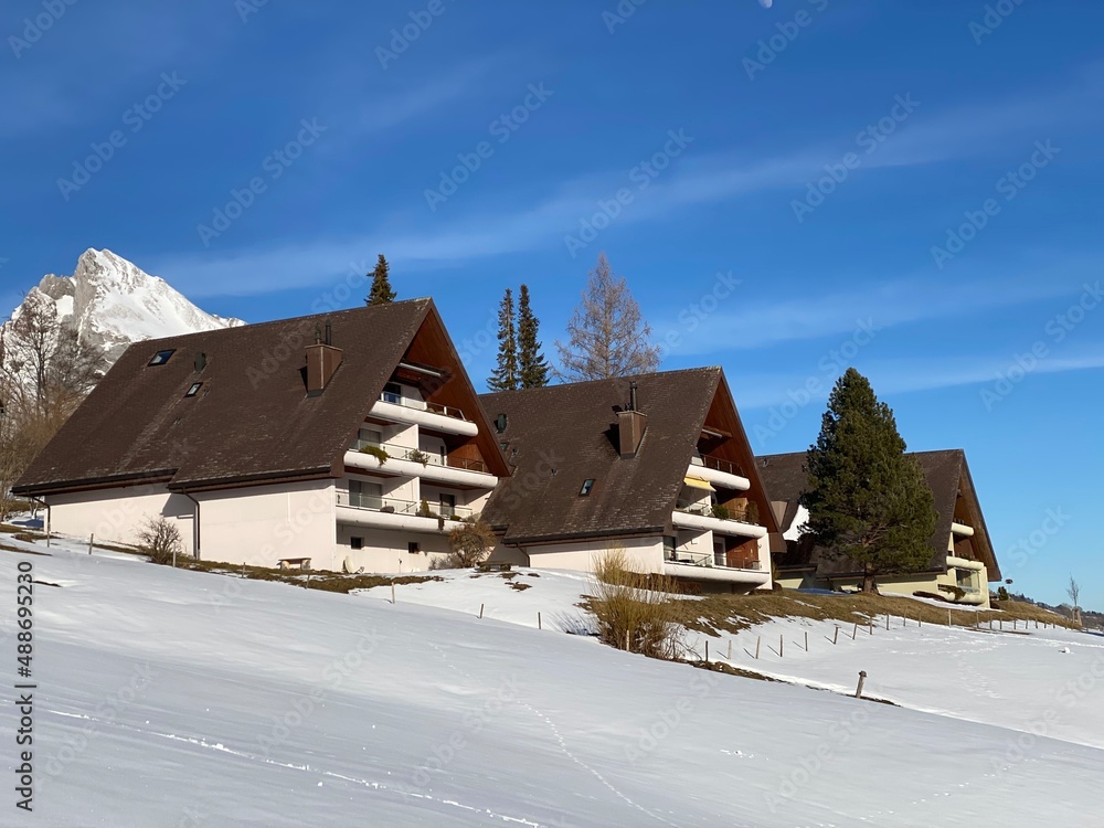 Traditional Swiss architecture and wooden alpine houses in the winter ambience of fresh white snow cover, Alt St. Johann - Obertoggenburg, Switzerland (Schweiz)