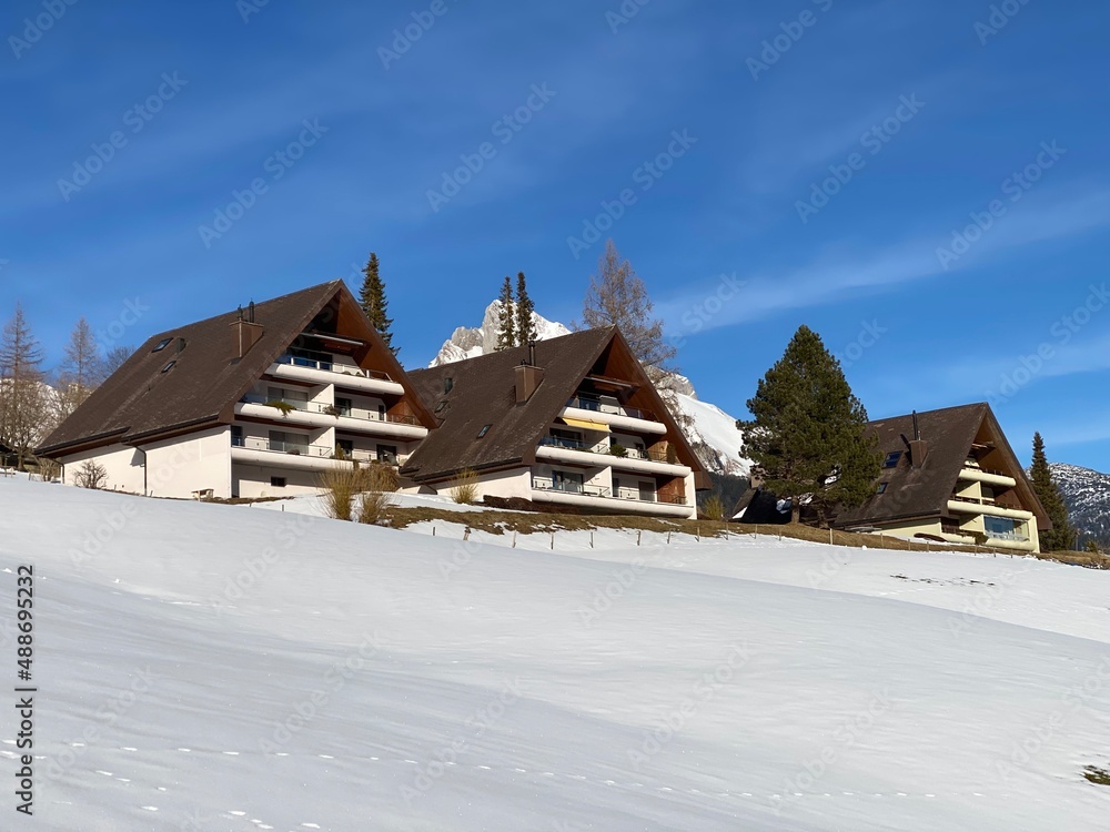 Traditional Swiss architecture and wooden alpine houses in the winter ambience of fresh white snow cover, Alt St. Johann - Obertoggenburg, Switzerland (Schweiz)