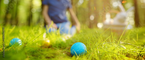 Canvas Print Little boy hunting for egg in spring garden on Easter day