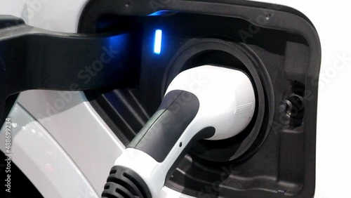 Close-up EV Car charging battery energy with plug charge from industrial electric charging machine on service station outdoor, a modern smart green energy zero emission for future