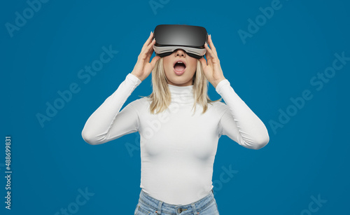 Amazed woman in VR glasses in studio