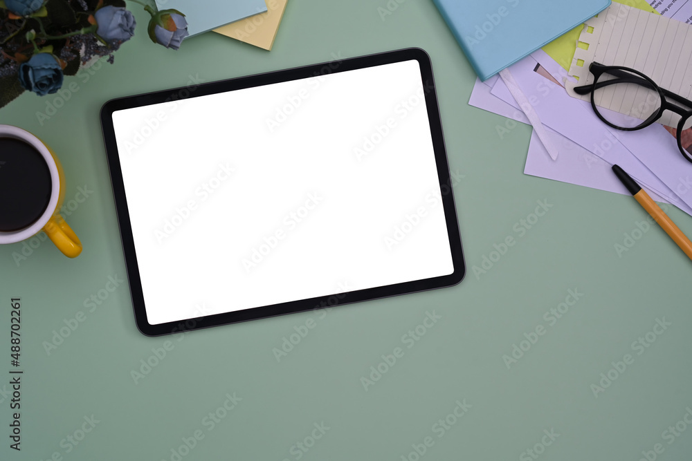 Top view digital tablet, sticky notes, notepad and coffee cup on green pastel background. Top view digital tablet, sticky notes, notepad and coffee cup on green pastel background.