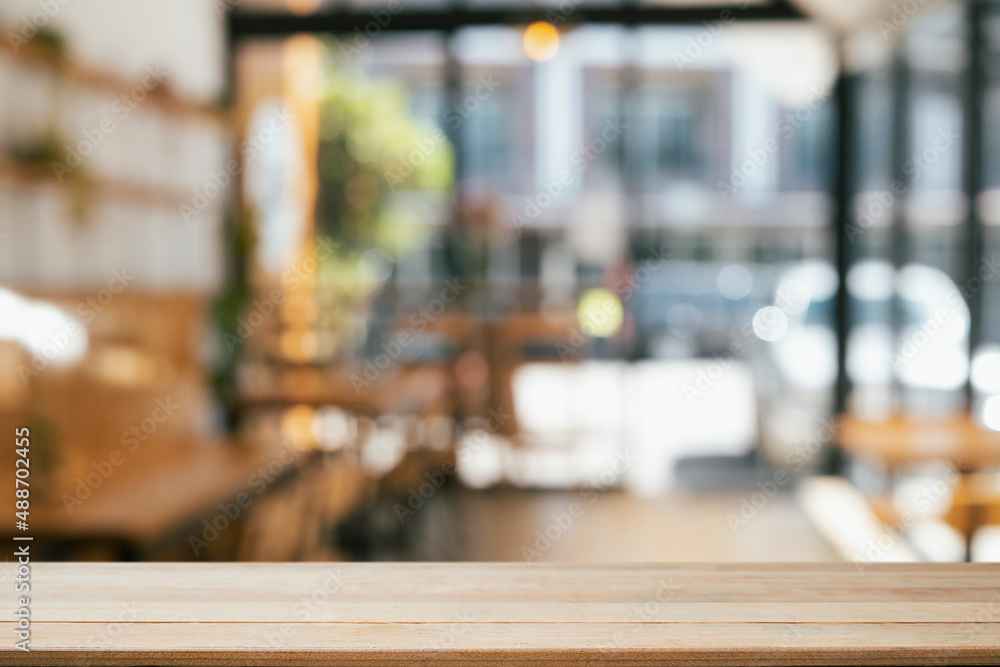 Empty wooden table in front of blurred background of coffee shop. Copy space for display or montage your products. Empty wooden table in front of blurred background of coffee shop. Copy space for display or montage your products.