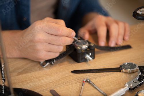 watchmaker try to repair watch with his tools photo