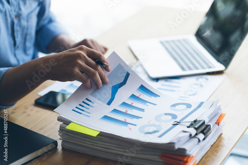 Businesswoman working in stacks of paperwork files for searching infomation unfinished documents about pile audit form on desk office and investigate financial doc in busy workload