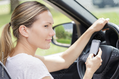 woman holding cellphone while driving © auremar