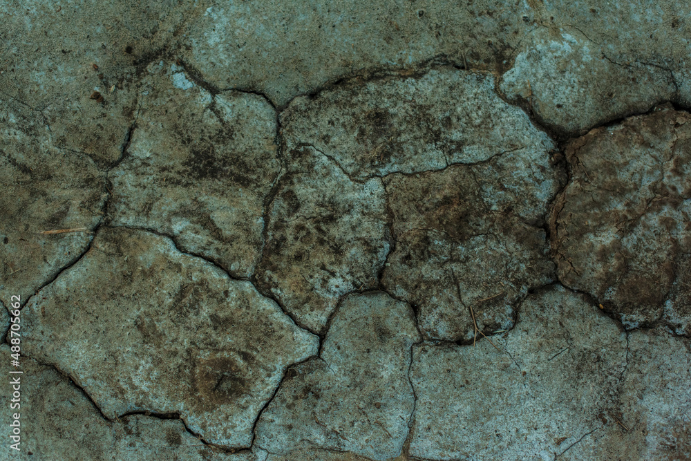 Texture of the dried earth. Dark green background with cracks and hollows. Drought and lack of moisture in the soil. The consequences of abnormal heat. Environmental disaster. Global warming. Texture of the dried earth. Dark green background with cracks and hollows. Drought and lack of moisture in the soil. The consequences of abnormal heat. Environmental disaster. Global warming.