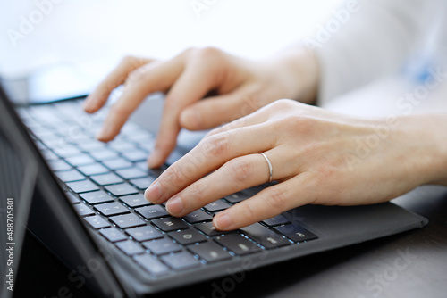 ノートパソコンでタイピングをするアジア人の女性の手元 