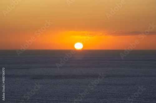 The sun is above the horizon during sunset at sea