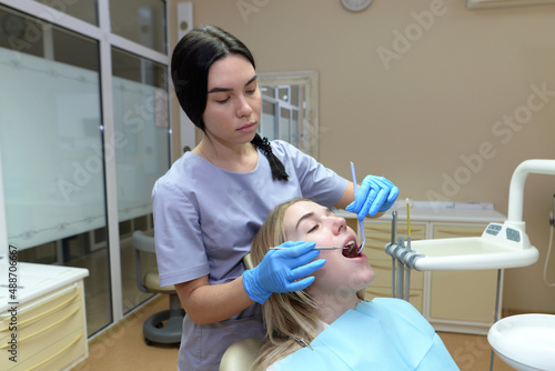 The dentist examines the patient s teeth in the dental office.