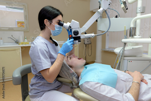 Female dentist examines a young beautiful woman