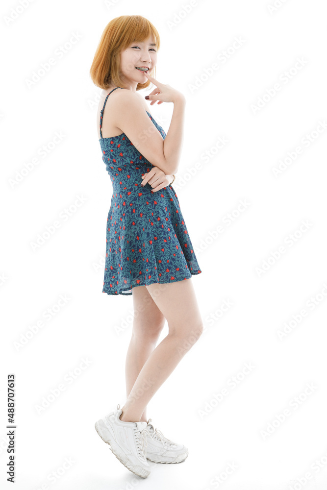 Isolated cutout studio full body shot of Asian young sexy blonde short hair female fashion model in camisole dress and sneakers standing holding hand touching lips crossed arm on white background Isolated cutout studio full body shot of Asian young sexy blonde short hair female fashion model in camisole dress and sneakers standing holding hand touching lips crossed arm on white background