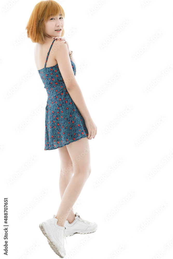 Naklejka premium Isolated cutout studio full body shot of Asian young sexy blonde short hair female fashion model in camisole dress and sneakers standing look at camera on white background