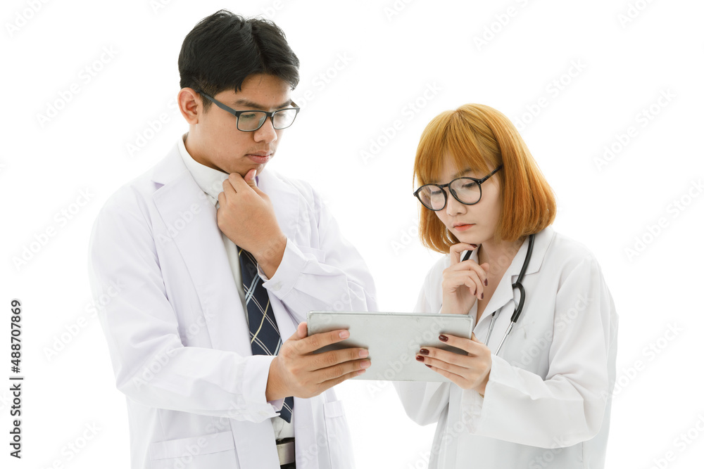 Isolated cutout studio shot of Asian young professional male doctor in lab coat with stethoscope and eyeglasses standing holding tablet discussing patient data with female intern on white background Isolated cutout studio shot of Asian young professional male doctor in lab coat with stethoscope and eyeglasses standing holding tablet discussing patient data with female intern on white background