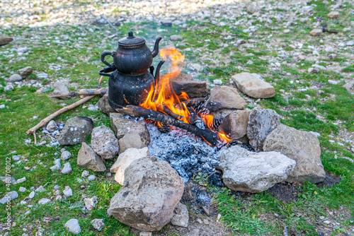 Teapot on the fire in the nature at camping