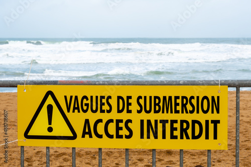Météo - Alerte tempête: Panneau de signalisation interdisant l'accès aux plages du littoral Atlantique avec le message "Vagues de submersion - Accès interdit" écrit en Français