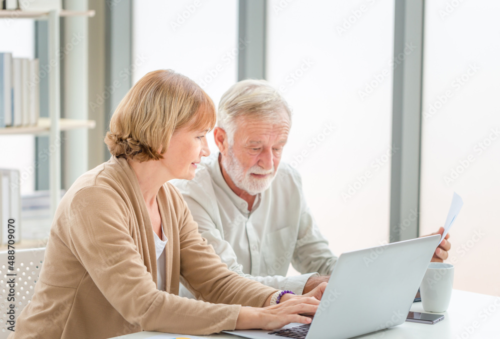 Senior couple checking their bills, retired elderly old family reading documents Senior couple checking their bills, retired elderly old family reading documents