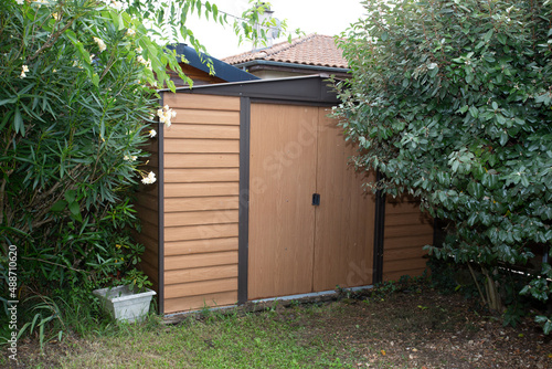 home garden storage shed in the house backyard on green trees background hut 