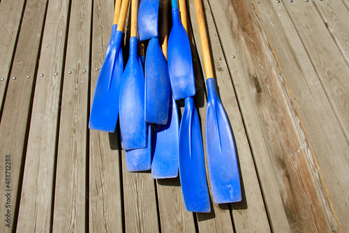 Blades of plastic paddles for canoes on the background of a wooden deck, the concept of rowing.Copy space.