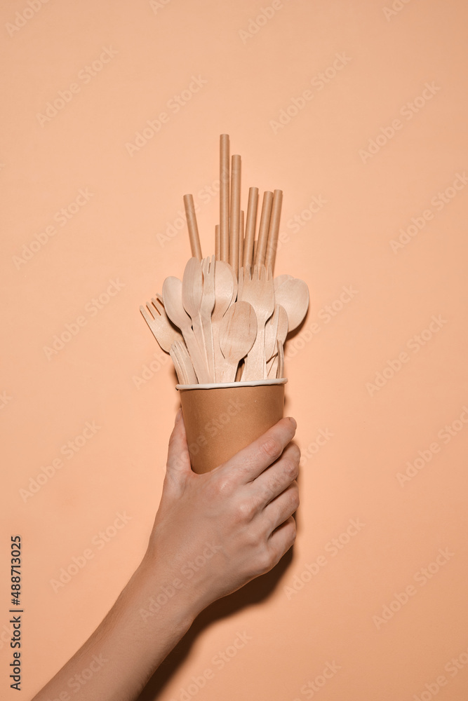 Wooden spoon, fork, paper cups gray background. Disposable tableware made of natural materials. The concept of a zero waste, sustainable lifestyle. Eco-friendly disposable tableware Wooden spoon, fork, paper cups gray background. Disposable tableware made of natural materials. The concept of a zero waste, sustainable lifestyle. Eco-friendly disposable tableware