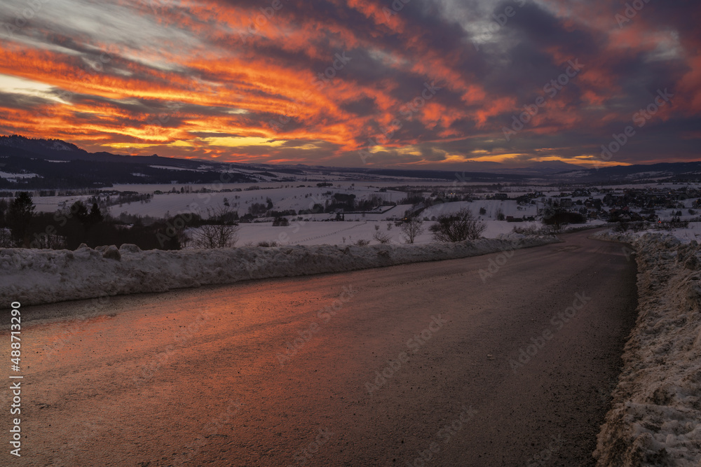 mountain road in snowy winter during a magnificent sunset