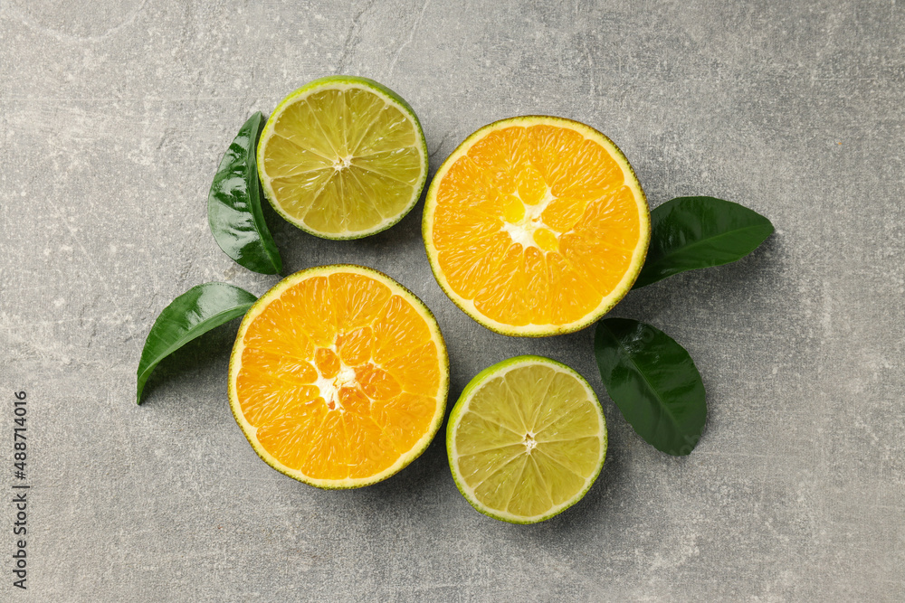 Chocolate orange and lime with leaves on gray textured background Chocolate orange and lime with leaves on gray textured background