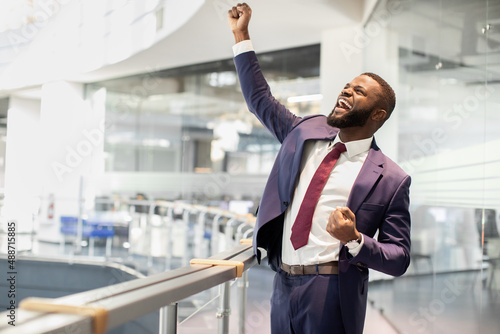 Cheerful african american young businessman celebrating success