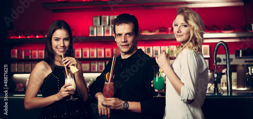 A groop of people drink cocktails in a bar banner size photo