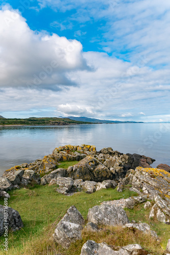 Coastline of the Isle of Islay with rocks and blue cloudy sky on a summer day