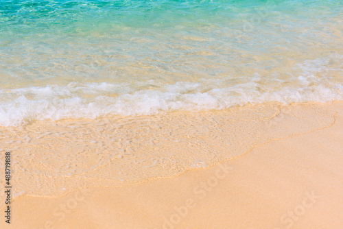 Summer scene with blue sea water and yellow sand close up with selective focus. Vacation or holiday concept. Nature background with copy space © Rina Mskaya