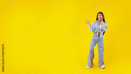 Excited woman pointing aside at copy space