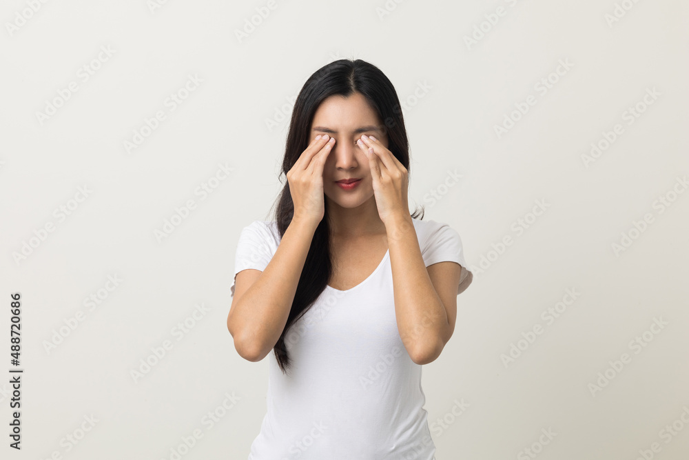Young asian beautiful woman hand rubbing eyes she's feeling depressed stress headache be tired from working standing on isolated white background she has health problems. Young asian beautiful woman hand rubbing eyes she's feeling depressed stress headache be tired from working standing on isolated white background she has health problems.
