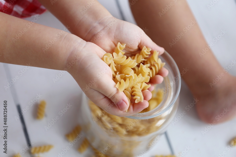 fusilli pasta in the hands of a girl fusilli pasta in the hands of a girl