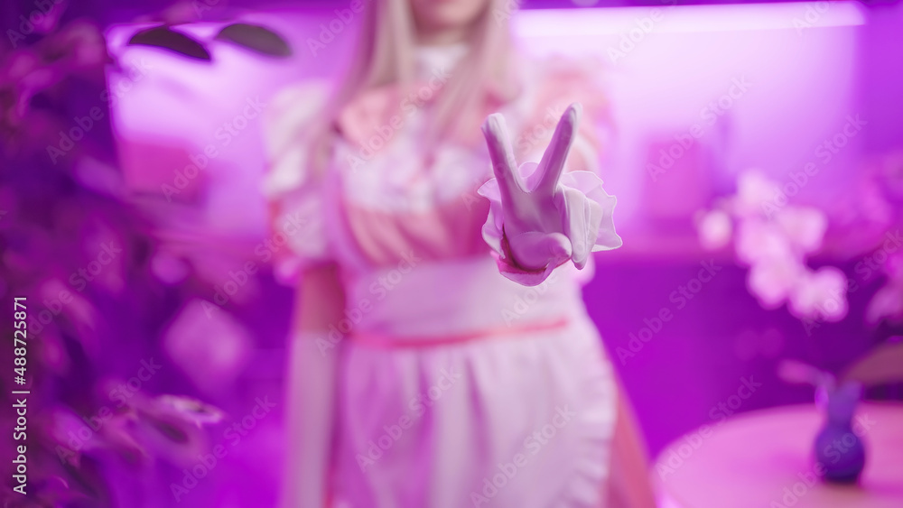 Headless pink maid cosplay show piece sign gesture with fingers in kitchen